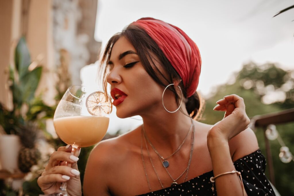 Attractive Brunette Haired Girl With Pink Headband Round Silver Earrings Bright Bandana Black Shirt Drinking Cocktail 1 1024x683