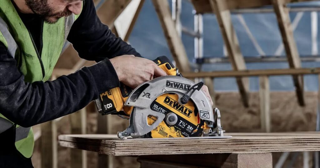 A worker in a hi-vis vest cutting plywood in a roof space with a DeWalt XR cordless circular saw running a 7 1/4 inch blade