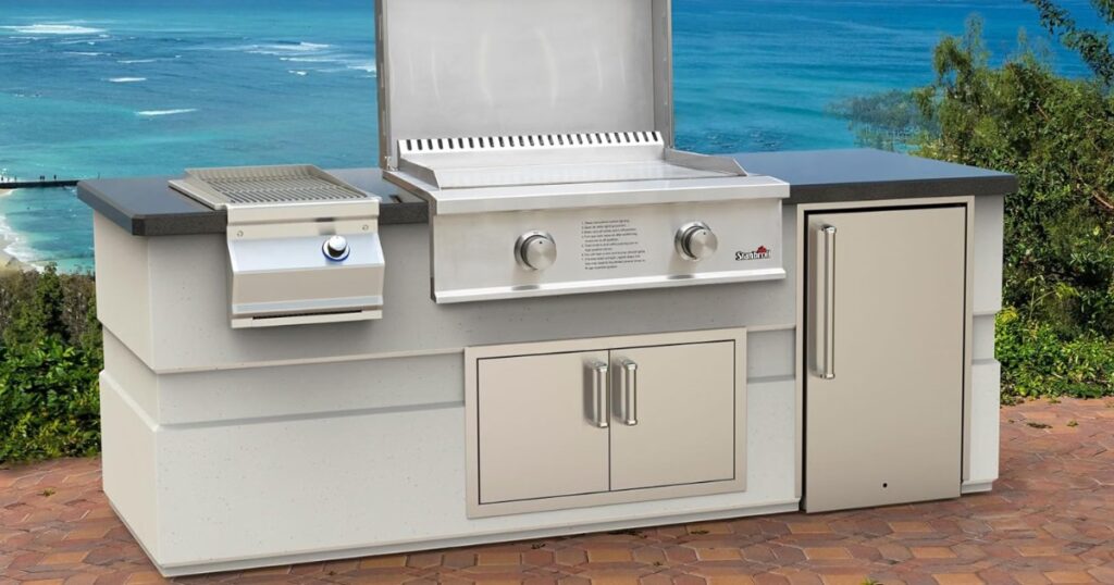 Stanbroil built-in griddle in a finished outdoor kitchen island with the lid raised, showing the flat cooking surface and the flange resting on the countertop beside a side burner