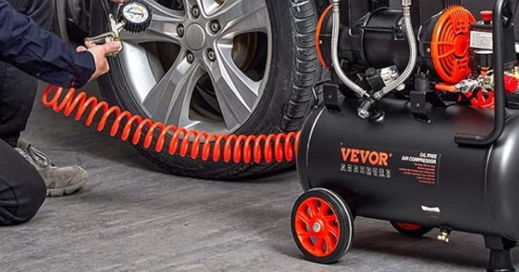 A person using an air line from a VEVOR oil-free air compressor to inflate a car tyre with a pressure gauge