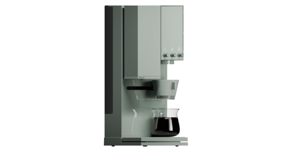 The xBloom Studio in sage green, showing the grinder column, three control knobs under the display, the dripper arm and a glass server on the drip tray